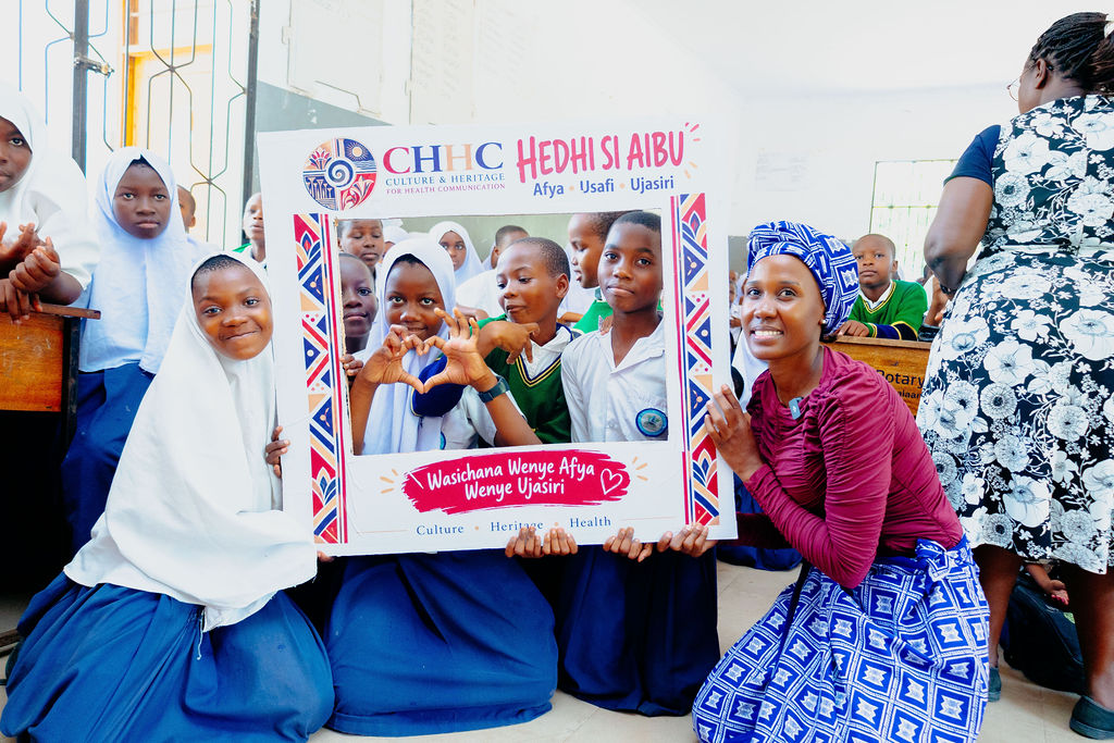Schoolgirls and facilitators sharing a menstrual health campaign message